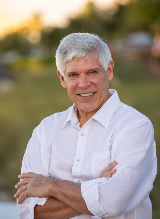 Dr. Paul M. Parker in a white dress shirt outside.