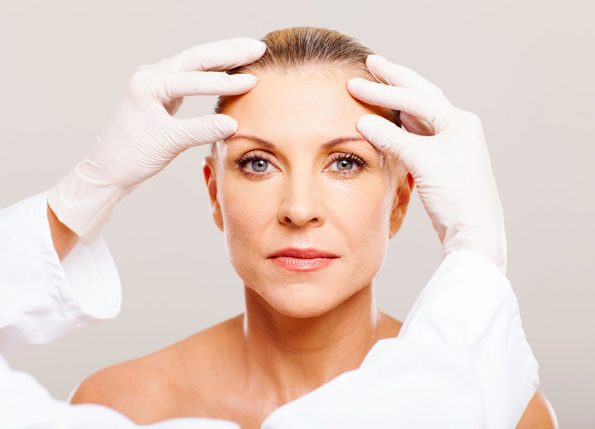 plastic surgeon assessing a patient
